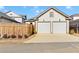 Two-car garage with white doors, a driveway, and a wooden fence at 1360 Flora Dr, Conyers, GA 30094