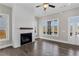 Living room featuring a fireplace with white shiplap, wood floors, and lots of natural light from the windows at 1360 Flora Dr, Conyers, GA 30094