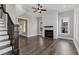 Open-concept living room with wood floors, a ceiling fan, fireplace with white shiplap, and lots of natural light at 1360 Flora Dr, Conyers, GA 30094