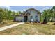 Charming single-Gathering home with stone accents, blue siding, a well-manicured lawn, and lush tree line at 2446 Naples St, Hoschton, GA 30548