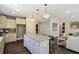 Open-concept kitchen featuring an island with a granite countertop, pendant lighting, and stainless steel appliances at 2446 Naples St, Hoschton, GA 30548