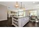 Spacious kitchen with a large center island, wood floors, and an adjacent dining area at 2446 Naples St, Hoschton, GA 30548