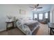 Main bedroom with a ceiling fan, plush carpet flooring, and natural light from bright windows at 5160 Meridian Pass, Cumming, GA 30028