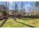Lush green backyard with mature trees and a playground at 2715 Kaley Nw Ln, Kennesaw, GA 30152