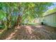 Partially shaded backyard with leafy ground cover, adjacent house, and AC unit at 5500 Marbut Forest Way, Lithonia, GA 30058