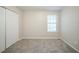 Bedroom featuring neutral walls, a large window, closet, and neutral carpeting at 5500 Marbut Forest Way, Lithonia, GA 30058