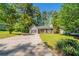 Charming single-Gathering home featuring a well-maintained lawn, mature trees, and a long driveway at 5500 Marbut Forest Way, Lithonia, GA 30058