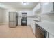 Functional kitchen featuring white cabinets, stainless steel appliances, and a tiled floor at 5500 Marbut Forest Way, Lithonia, GA 30058