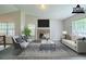 Bright, staged living room featuring vaulted ceilings, a brick fireplace and large windows for natural light at 5500 Marbut Forest Way, Lithonia, GA 30058