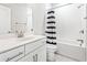 Well-lit bathroom features a shower-tub combo, white subway tile, and a vanity with sleek hardware at 677 Brennan Dr, Decatur, GA 30033