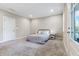 Neutral bedroom featuring plush carpet, a metal bed frame, and a doorway to an outdoor area at 677 Brennan Dr, Decatur, GA 30033
