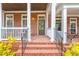 Inviting brick front porch with white columns, and a cozy seating area at 677 Brennan Dr, Decatur, GA 30033