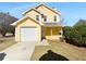 Charming yellow two-story home with attached garage and inviting front porch at 1090 Ohara Dr, Jonesboro, GA 30236