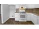 Well-lit kitchen featuring white cabinets, laminate countertops, and an electric range at 1090 Ohara Dr, Jonesboro, GA 30236