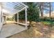 An outdoor patio featuring a pergola and seating, surrounded by trees and shrubbery at 3744 Misty Wood Nw Dr, Marietta, GA 30064
