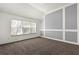 Bedroom featuring stylish grey accent wall, large windows, and neutral carpeting at 3744 Misty Wood Nw Dr, Marietta, GA 30064