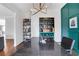 Home office features a teal accent wall, hardwood floors, and a built-in shelving unit at 2383 Colonial Ne Dr, Brookhaven, GA 30319