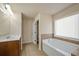 Well-lit bathroom with a soaking tub, tiled floor, and vanity with sink at 2592 Jacanar Sw Ln, Atlanta, GA 30331