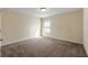 Bright carpeted bedroom with a single window and neutral color palette at 2592 Jacanar Sw Ln, Atlanta, GA 30331