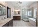 Elegant bathroom featuring a soaking tub, glass enclosed shower, double vanity and stylish lighting at 3979 Sentry Xing, Marietta, GA 30068