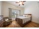 Cozy bedroom with hardwood floors, a ceiling fan, a large window, and a comfortable sitting chair at 3979 Sentry Xing, Marietta, GA 30068