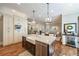 Modern kitchen island featuring a wine fridge, stainless steel dishwasher, and a farmhouse sink with a view to living spaces at 3979 Sentry Xing, Marietta, GA 30068