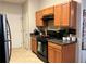 Kitchen with wood cabinets, black appliances, and dark countertop; a functional space for cooking and beverage preparation at 1281 Rockfield Cir, Norcross, GA 30093