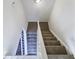 Carpeted staircase with white railings leading to the upper level of the home at 1444 Twin Branches Se Cir, Marietta, GA 30067