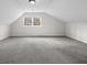 Bright attic space with gray carpet and large window at 1780 Williams Cir, Cumming, GA 30041