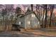 Charming two-story home features a wooden deck surrounded by trees and a partially paved driveway at 1780 Williams Cir, Cumming, GA 30041