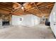 Spacious living room with stone fireplace, exposed wood ceiling and connection to unfinished kitchen area at 1780 Williams Cir, Cumming, GA 30041