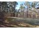 A vast backyard is surrounded by towering trees, offering tranquility and privacy in a natural setting at 460 Chandler Bluff Ct, Grayson, GA 30017