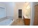 Bathroom featuring a dual sink vanity, soaking tub, tiled floor, and walk-in closet access at 460 Chandler Bluff Ct, Grayson, GA 30017