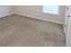 A simple bedroom with neutral walls, carpet floors, and a window for natural light at 460 Chandler Bluff Ct, Grayson, GA 30017