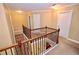 Hallway with wooden railing overlooking the foyer, neutral walls, and carpet floors at 460 Chandler Bluff Ct, Grayson, GA 30017