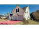 Two-story home featuring an attached two-car garage, and a well-maintained lawn at 477 Harvick Cir, Stockbridge, GA 30281