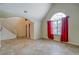 Bright living area with staircase, large windows dressed with red curtains, and tile floors at 477 Harvick Cir, Stockbridge, GA 30281