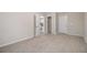 Spacious bedroom with plush carpeting, neutral walls, and multiple doorways creating versatile room at 100 Hunters Keep Trce, Covington, GA 30014