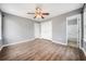 Bright bedroom with ceiling fan, gray walls, wood-look flooring, and closet doors at 1389 Ling Dr, Austell, GA 30168