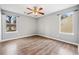 Bedroom featuring laminate floors, two windows for natural light, ceiling fan, and neutral color palette at 1389 Ling Dr, Austell, GA 30168