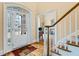 Welcoming foyer with hardwood floors, glass-paneled front door, and staircase at 6980 Polo Fields Pkwy, Cumming, GA 30040