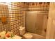 Bathroom with a shower/tub combo, tiled walls with a unique pattern, and a classic toilet at 1159 Bowerie Chase, Powder Springs, GA 30127