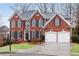 Charming red brick home featuring a manicured front lawn and a two-car garage at 1900 Sanborne Way, Dacula, GA 30019