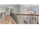 Hallway with hardwood floors, wrought iron railing, and chandelier at 1900 Sanborne Way, Dacula, GA 30019