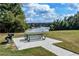 Outdoor picnic area with a grill and table, offering scenic views of the lake and green surroundings at 1900 Sanborne Way, Dacula, GA 30019