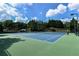 Community tennis court with green and blue surface surrounded by trees at 1900 Sanborne Way, Dacula, GA 30019