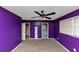 Bedroom features purple walls, carpet, a ceiling fan, and windows at 2458 Kelly Lake Dr, Decatur, GA 30032