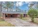 Back exterior view of the property with driveway and ample parking, covered carport, and a brick facade at 2458 Kelly Lake Dr, Decatur, GA 30032