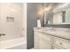 This bathroom features a tub with tile surround, granite counters, and cream colored cabinets at 2781 Hollywood Dr, Decatur, GA 30033