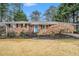 Charming brick home featuring a well-manicured front yard with mature trees and a bright blue front door at 2781 Hollywood Dr, Decatur, GA 30033